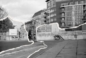 Eine Straße in der Stadt mit modernen Wohngebäuden und einem Teil der Berliner Mauer, dargestellt durch einen zerrissenen Collage-Effekt, der vergangene und gegenwärtige Szenen vermischt. (KI generierte Beschreibung)